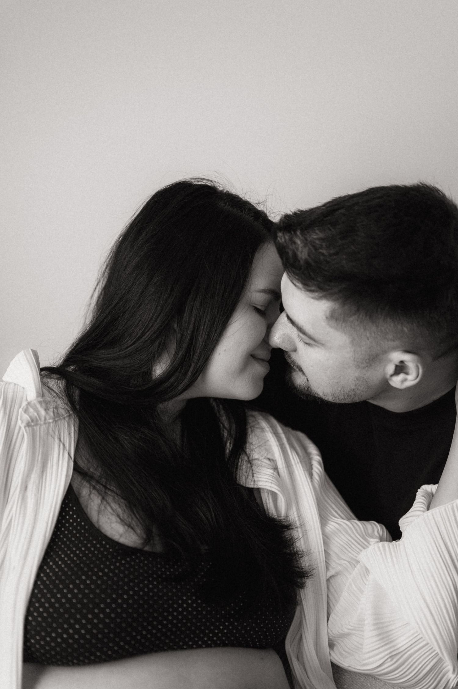 A romantic black and white photo sequence shows a couple sharing an intimate kiss against a light background.