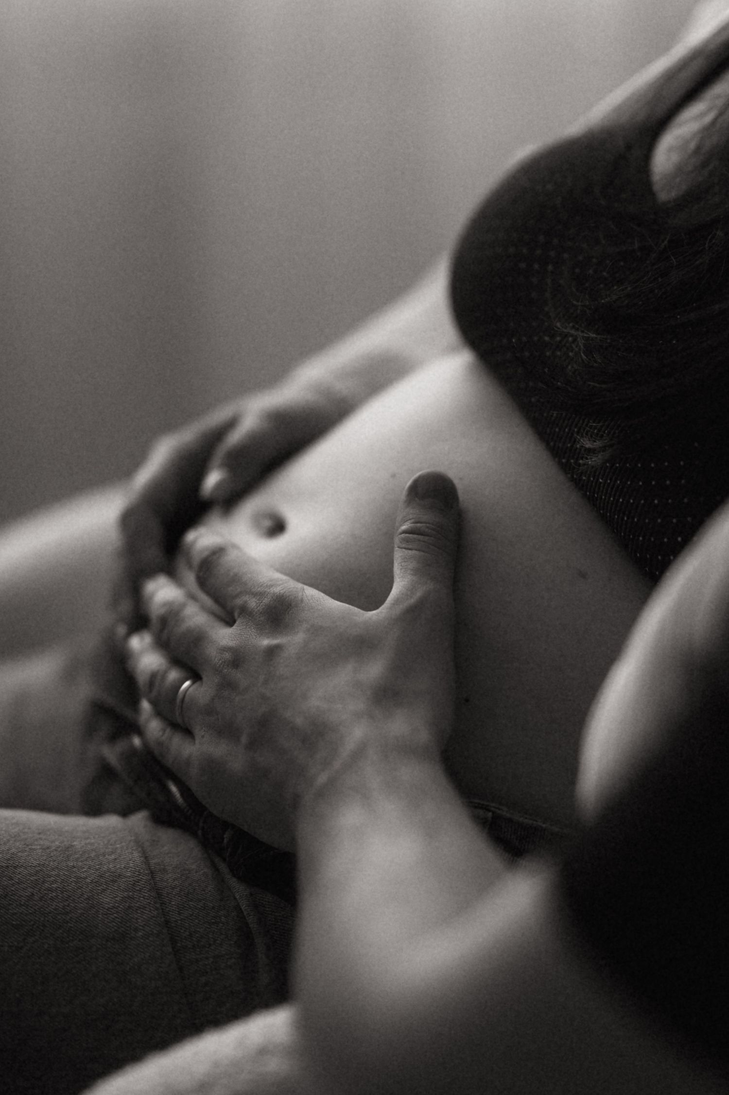 A tender black and white photograph capturing an intimate moment between a couple in soft focus.