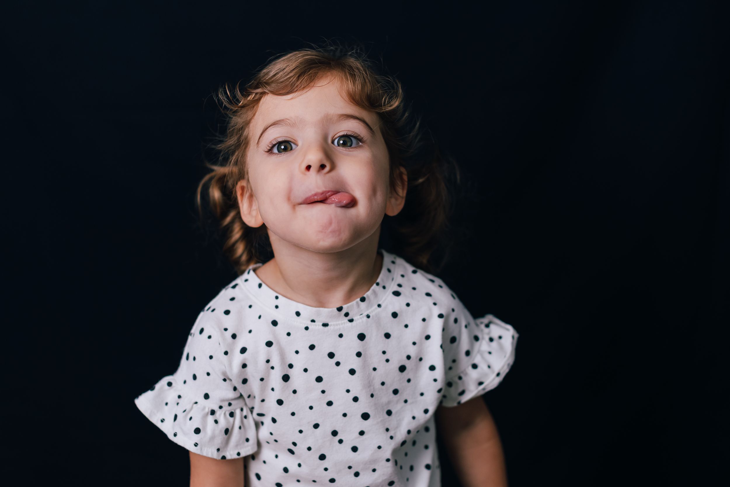 Black and white photo series showing a child's expressions changing from serious to joyful in four progressive shots.