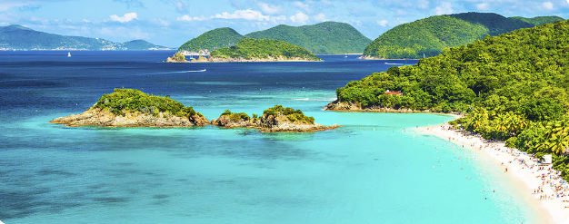 Aerial view of pristine turquoise waters and lush green islands in a tropical paradise with white sandy beaches.
