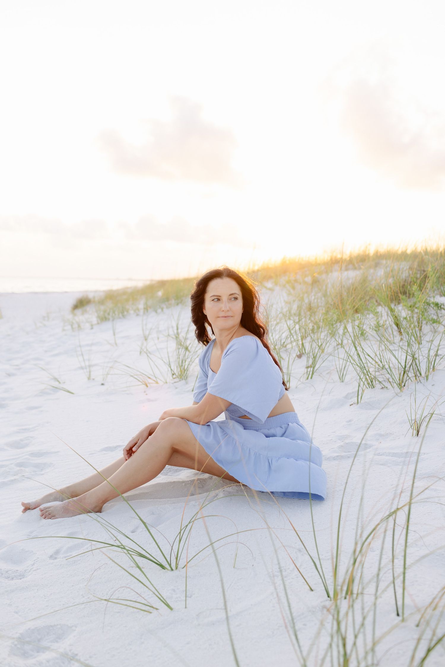 Woman sitting on sandy beach