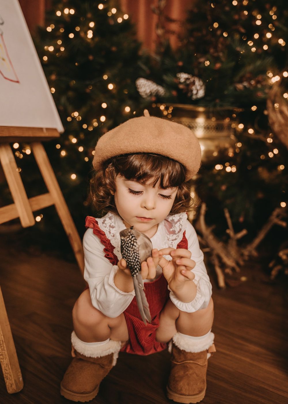 A vintage-styled holiday photo with an art easel and Christmas tree decorations in warm sepia tones.