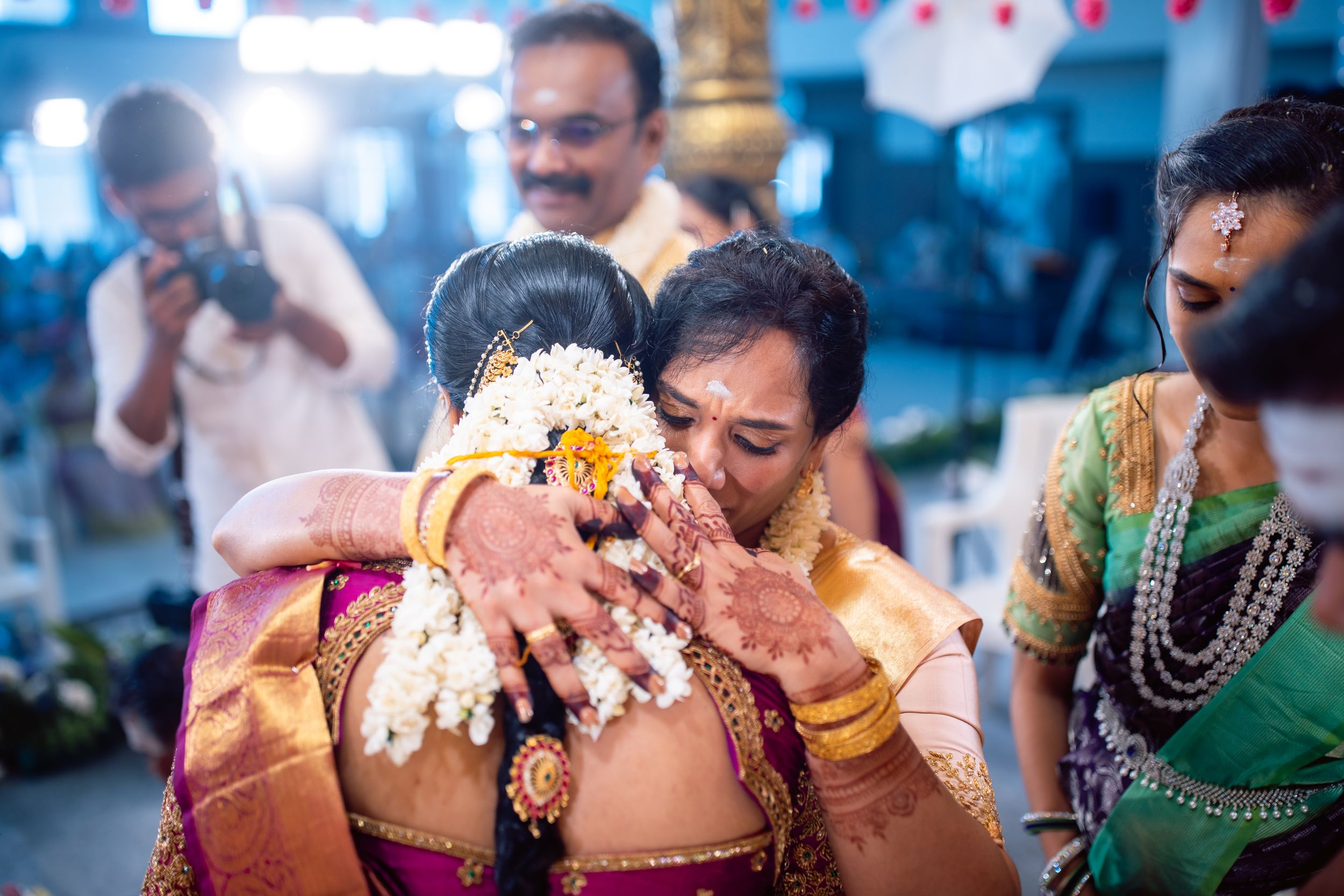 Emotional candid moment of a bride hugging her mother during a South Indian wedding at Eeebees Mahal, Erode. Captured by Jeno Photography, s