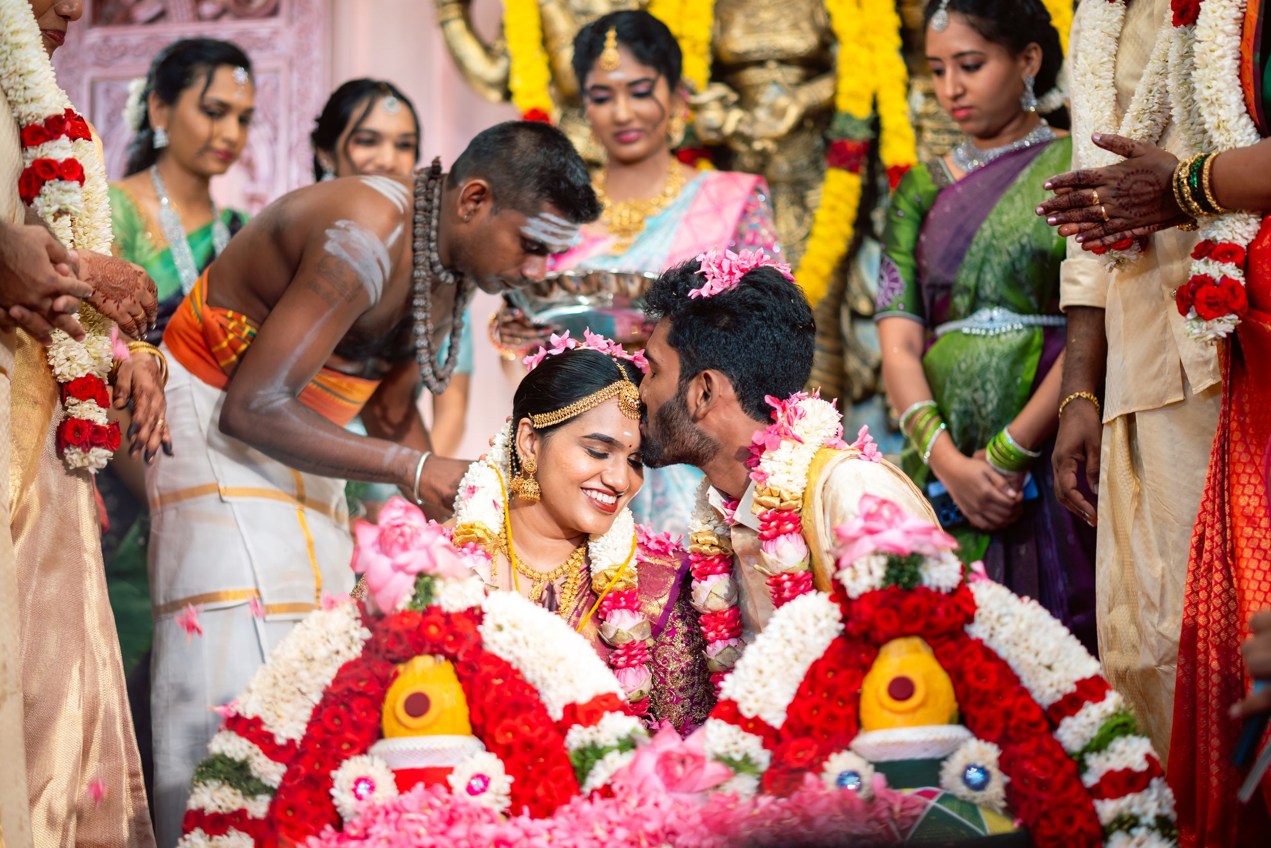 groom kissing bride after tieing the thali captured by Jeno Photography