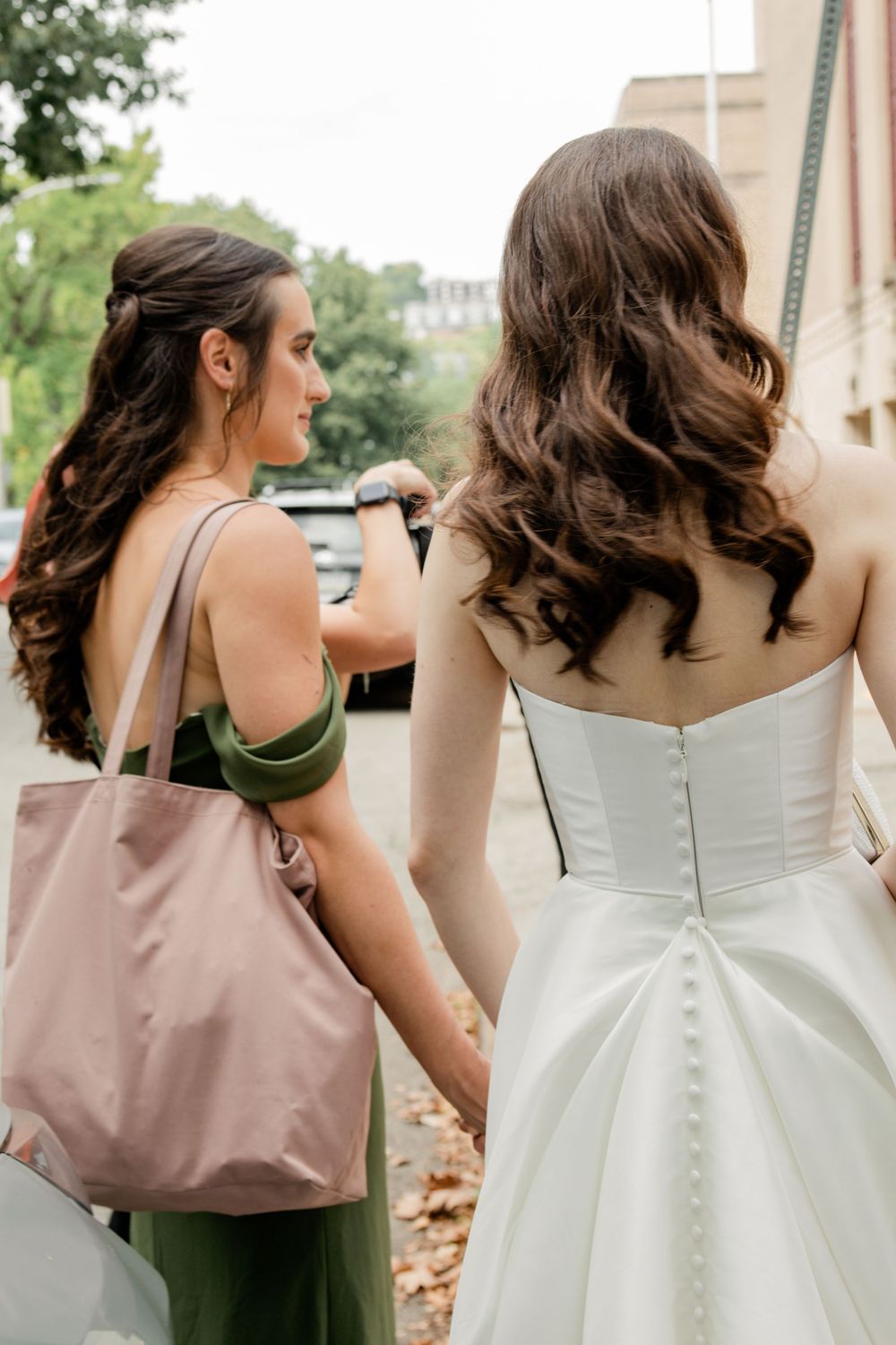A series of four photos showing the back details of a white wedding dress with buttons and bridesmaids in mauve dresses.