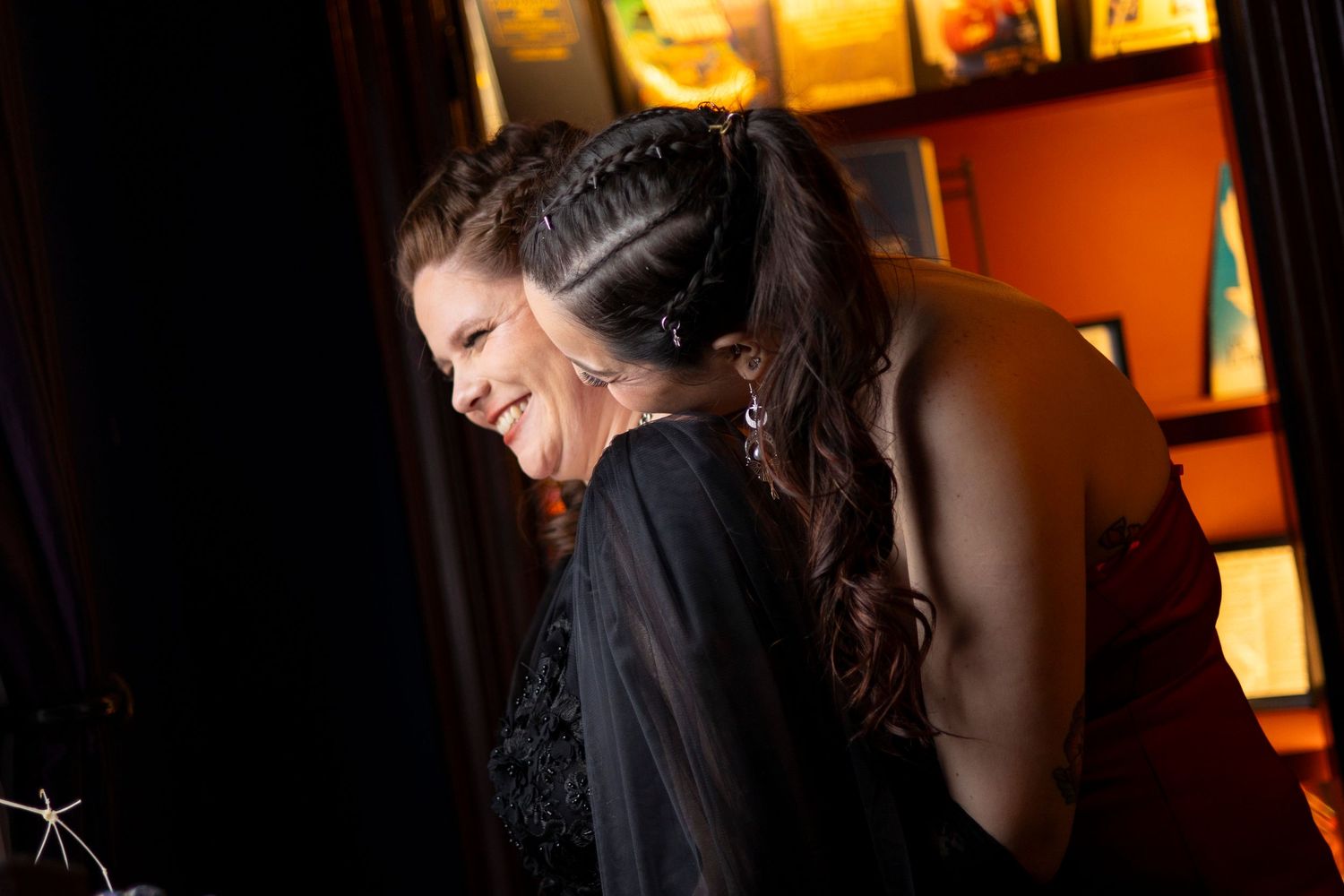 A queer couple embraces each other and laugh together.