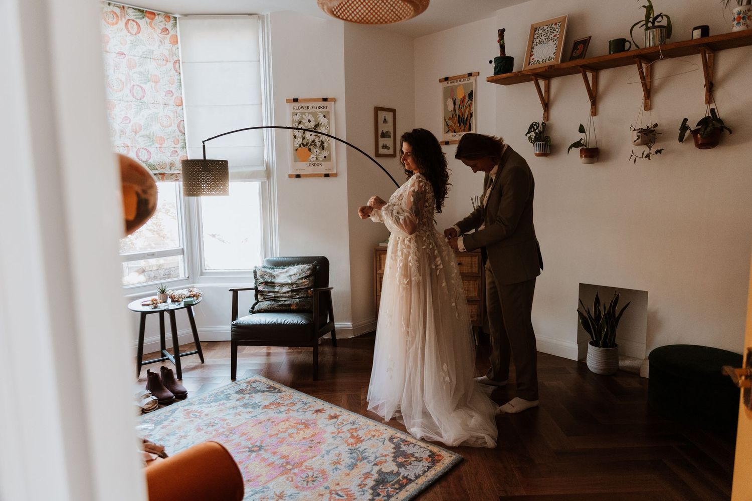 A couple helping each other get ready during their wedding morning.