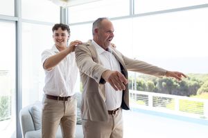 grooms prep, son fixing his dads jacket before the ceremony candid wedding photography