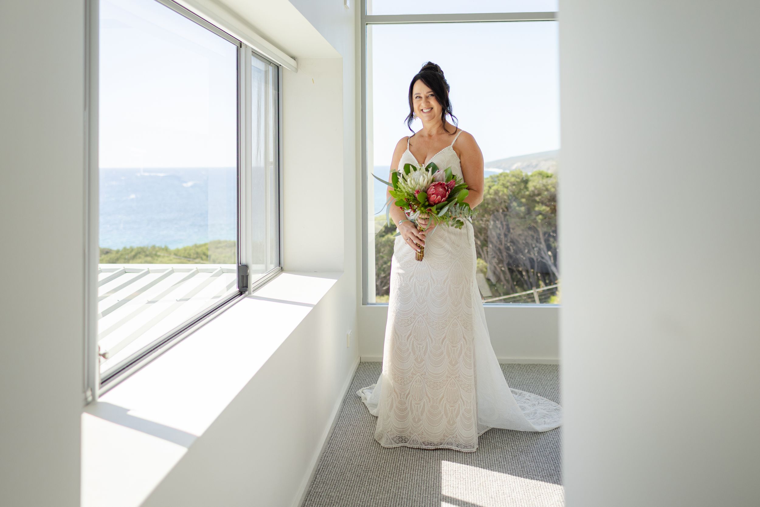 candid bridal portraits in a modern room with ocean views.
