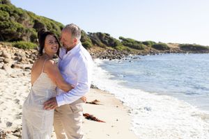 Romantic beach wedding photoshoot with couple embracing on sandy shoreline Kirsten Graham Wedding Photography