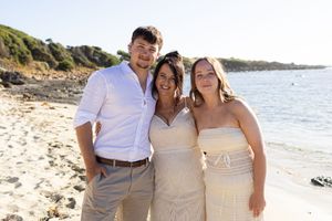 family poses together on a beach, intimate wedding