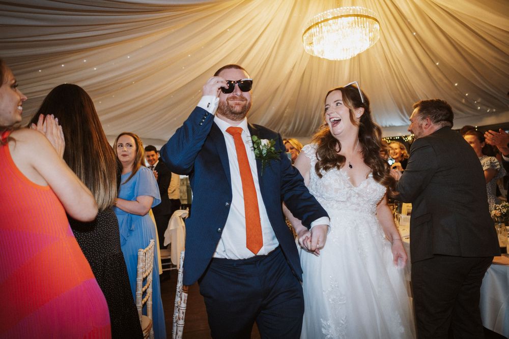 Wedding celebration sequence showing dancing and joyful moments under draped fabric ceiling decor.