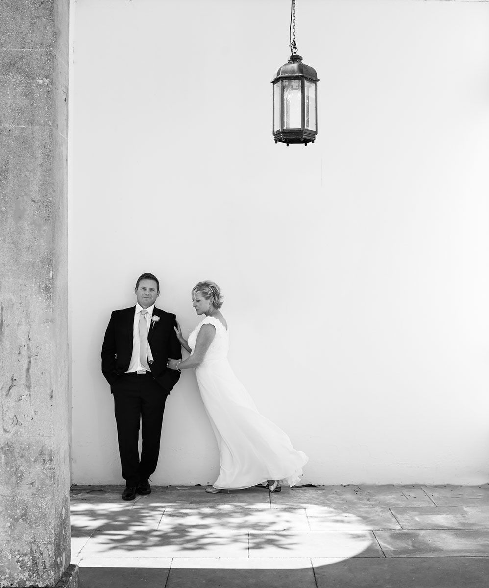 Bride and groom in stylish pose in grounds of Buxted Park Hotel