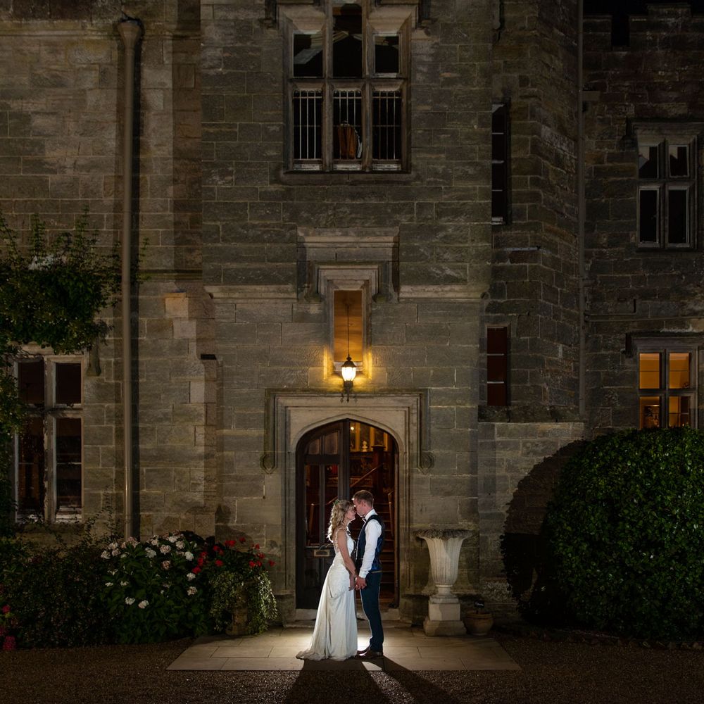 Night shot of bride and groom outside Wadhurst castle, East Sussex