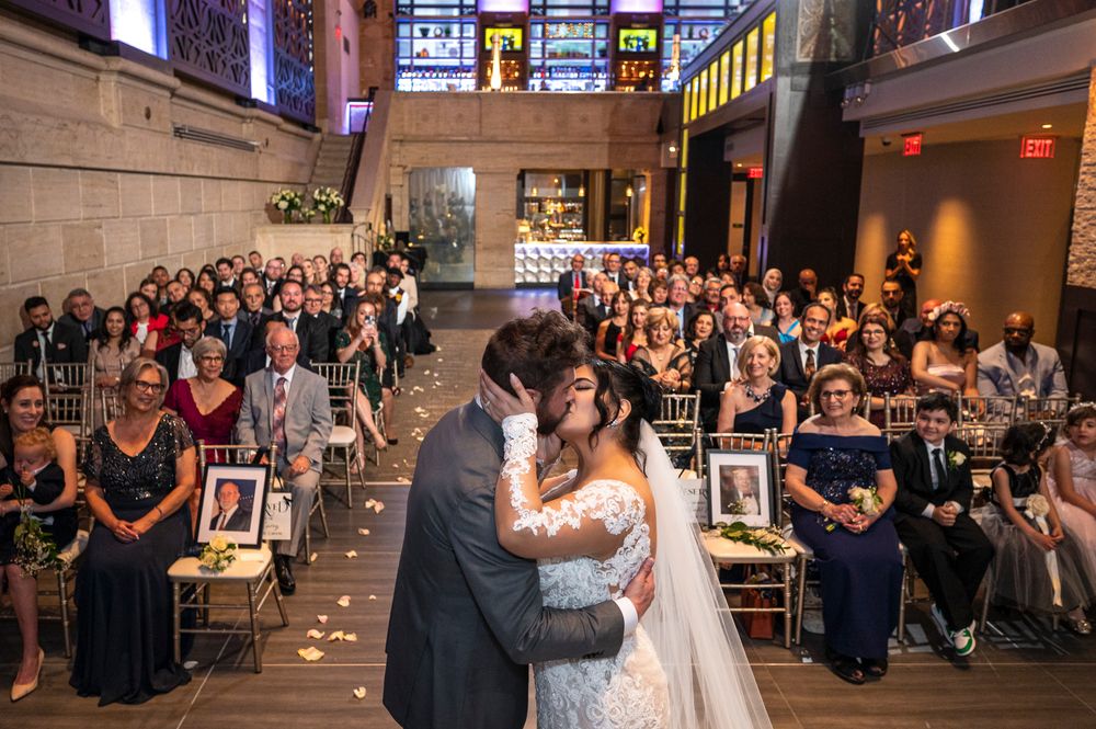 A couple shares their ceremony at a wedding at Union Trust while guests watch from the surrounding tables.