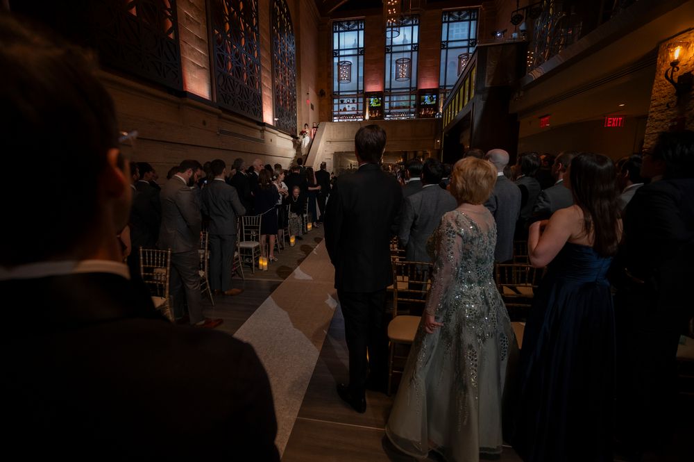 Dimly lit church interior with guests seated in rows during an evening wedding ceremony at a Union Trust wedding