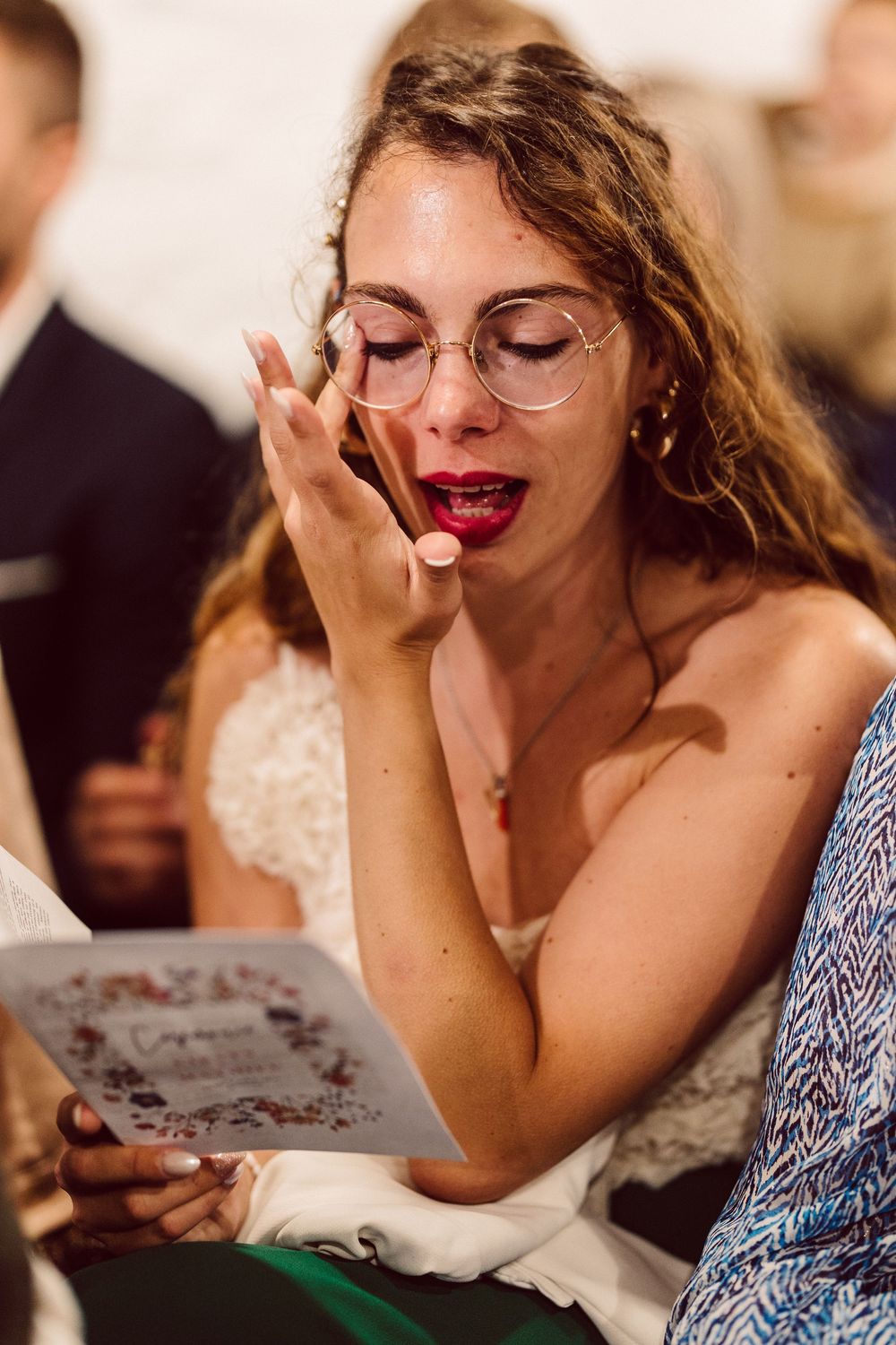 Close-up shots of wedding guests reading and reacting emotionally to cards or letters.