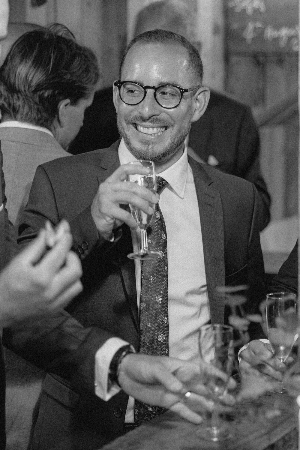 Black and white photo sequence showing people in formal attire enjoying drinks and conversation at a social gathering.