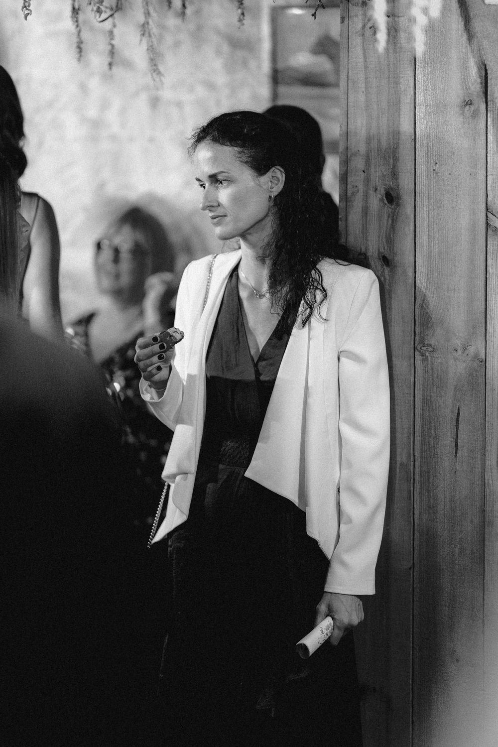 Black and white photo series showing a person in a white blazer against a wooden wall.