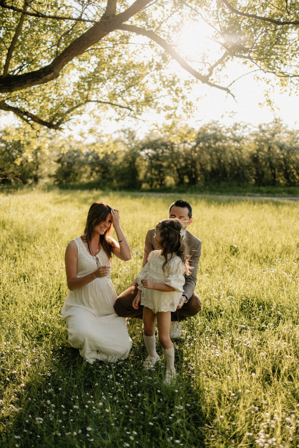 Couple shares intimate moments in a sunlit meadow with wildflowers during golden hour photography session.