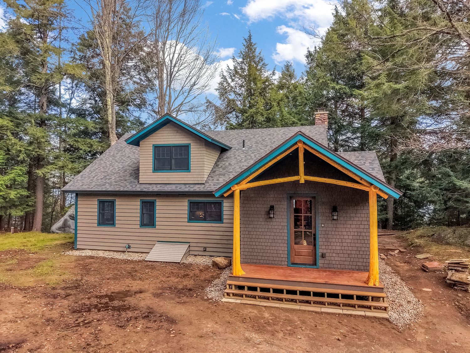 Exterior aerial views of rustic lakeside cabins nestled among trees with wooden decks and natural surroundings.
