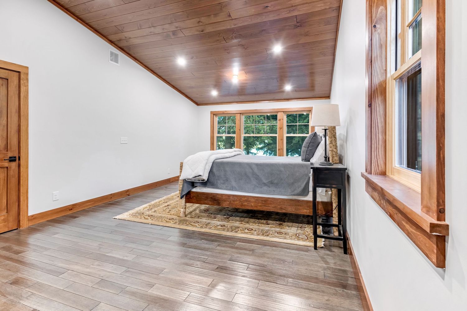 Modern home interior with wood trim windows, recessed lighting, and light hardwood flooring in an open concept space.