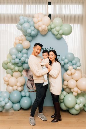 Balloon arch installation with soft pastel colors in blue, peach and mint creates an elegant backdrop for a special occasion.