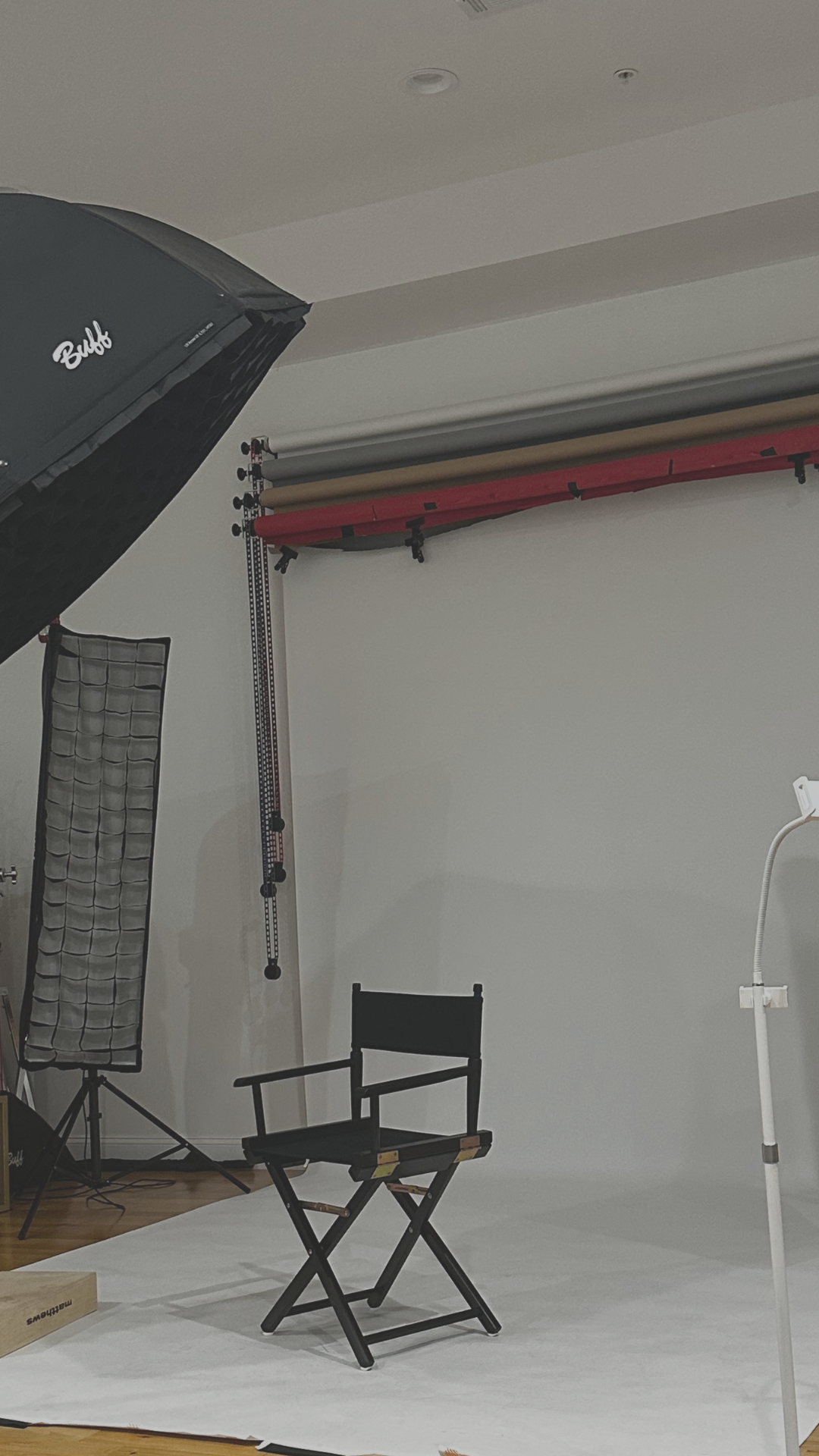 A series of studio photography setup images showing lighting equipment and a director's chair in a white room.