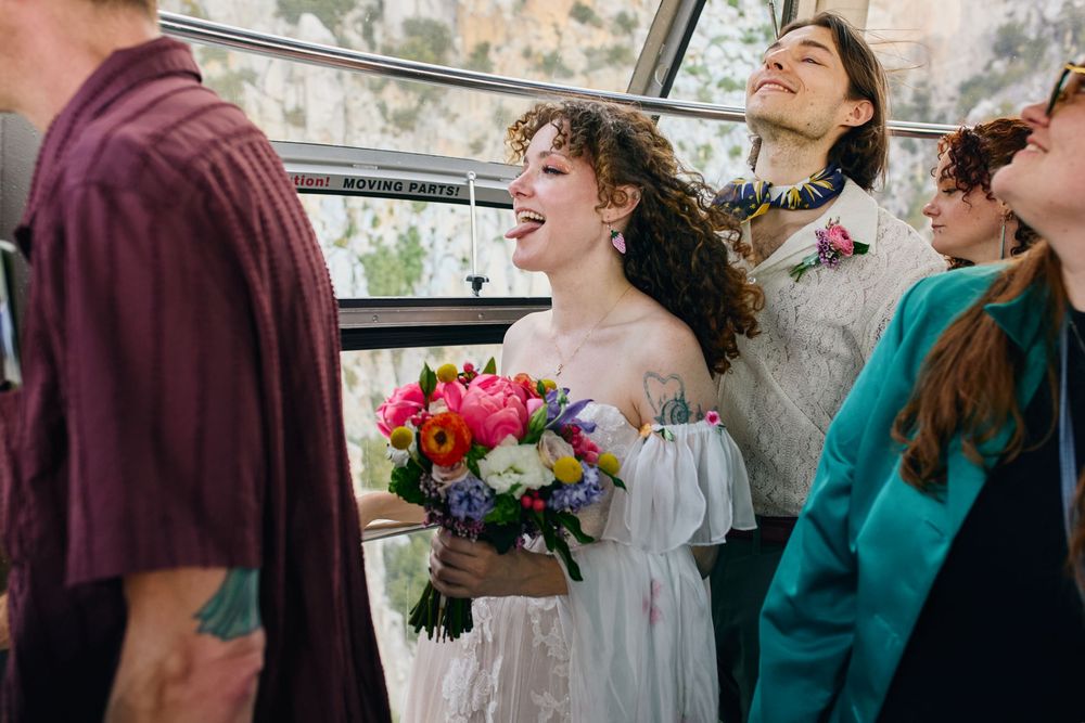 A wedding party shares joyful candid moments with each other surrounded by a warm glow of natural light.