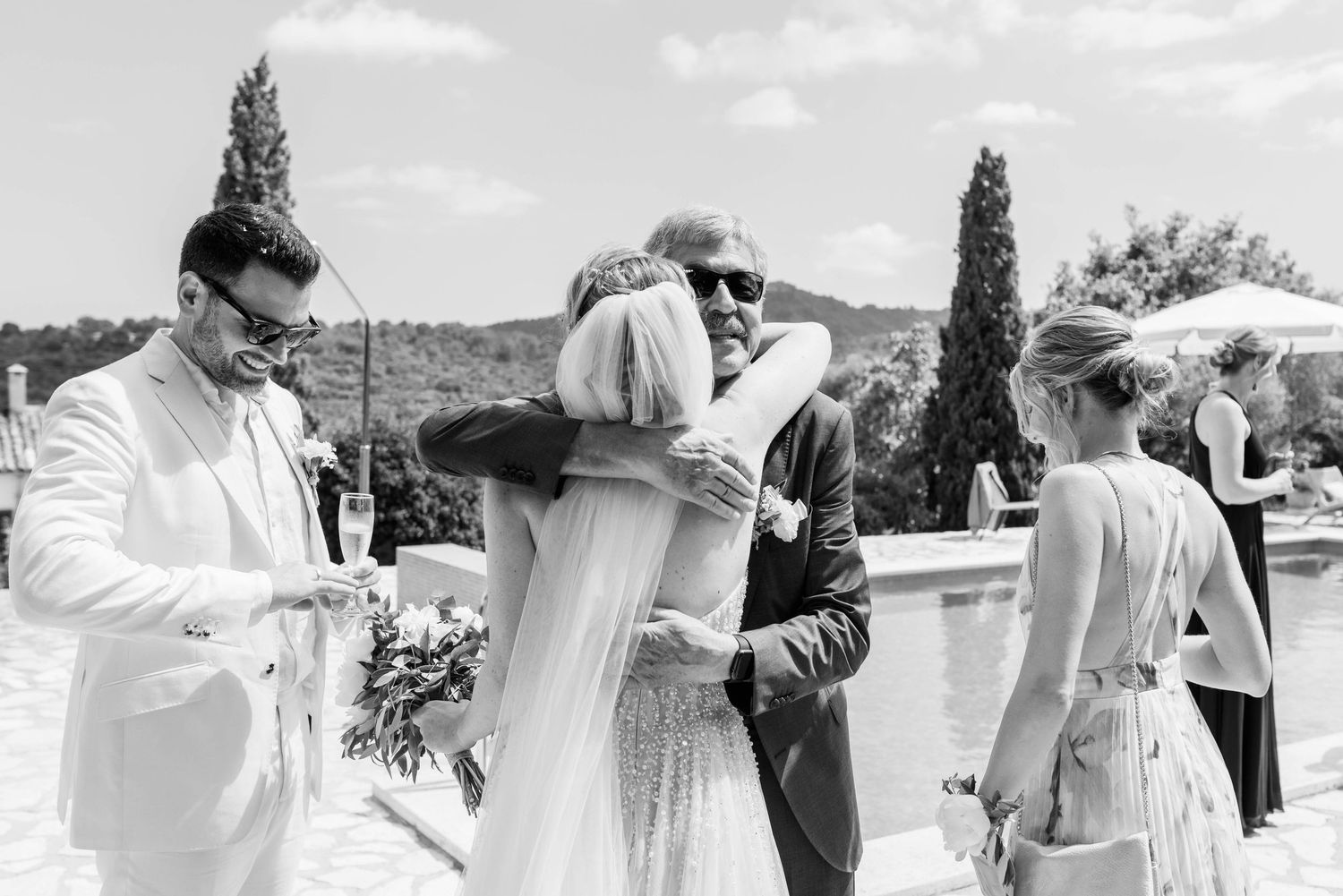 Black and white sequence of photos showing couple embracing and sharing a romantic moment outdoors by the water.