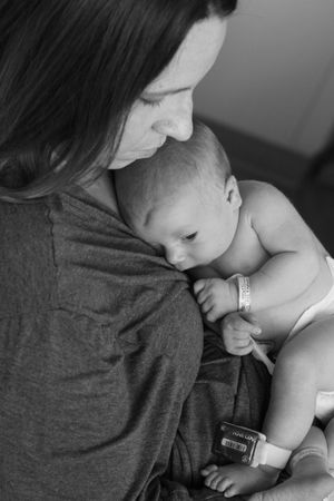 Tender moment between mother and infant in black and white photography.