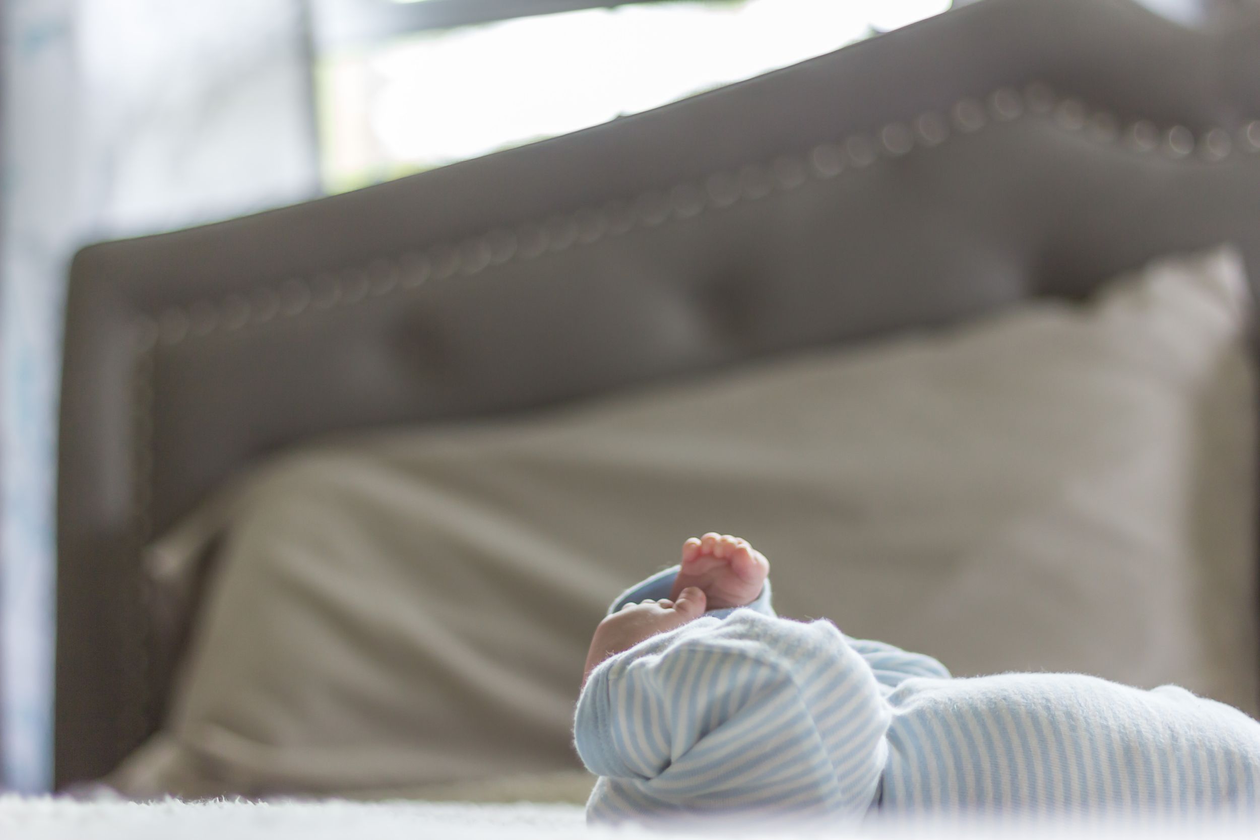 Tender moment captured during newborn photography session in natural window light.