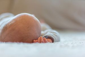 Peaceful sleeping newborn photographed in soft natural lighting.