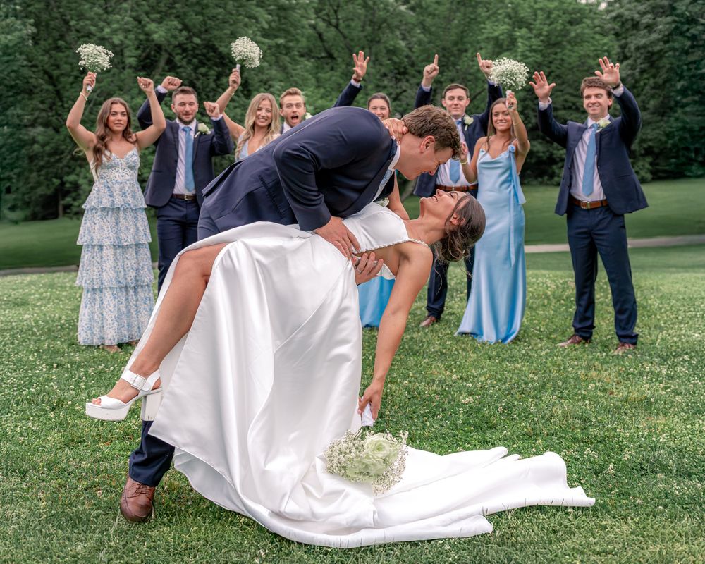 Bride and groom share a dramatic first kiss dip in a church aisle during an elegant New England wedding ceremony celebration.