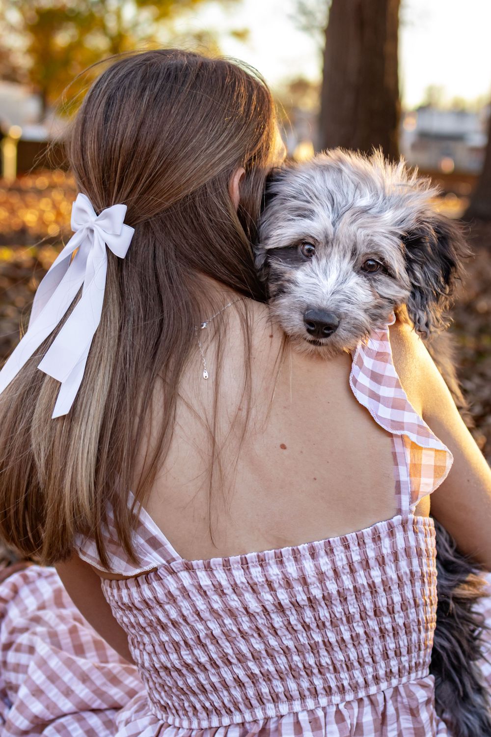 a women holding a dog over her shoulder