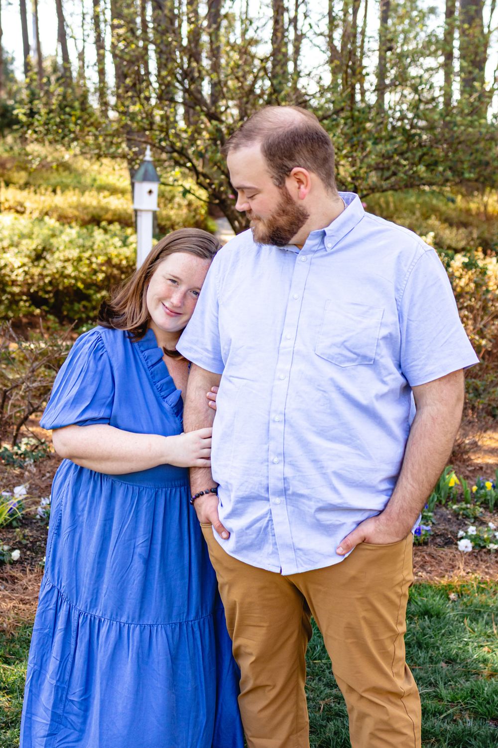 a close up portrait of a man and women smiling in a garden
