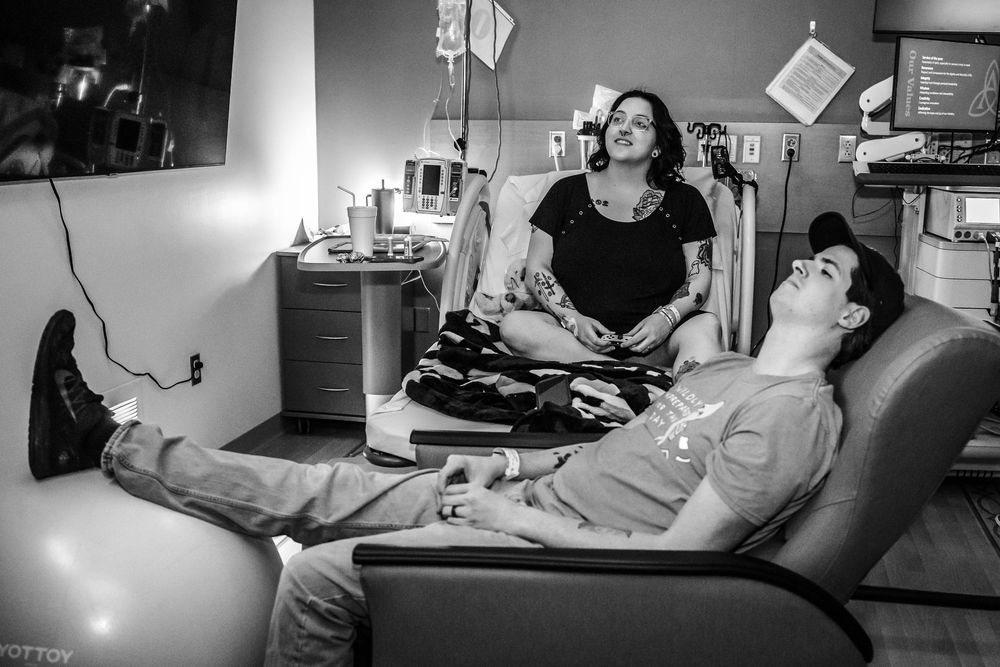Patient resting in hospital bed while receiving medical care.