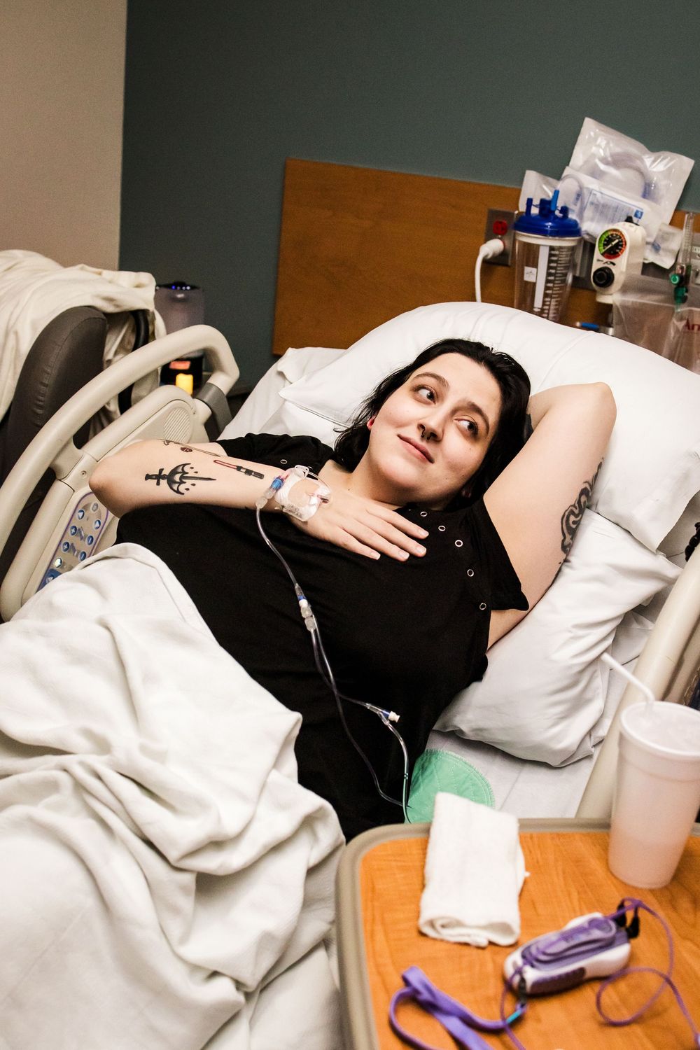 Patient lying in hospital bed with medical monitoring equipment visible.