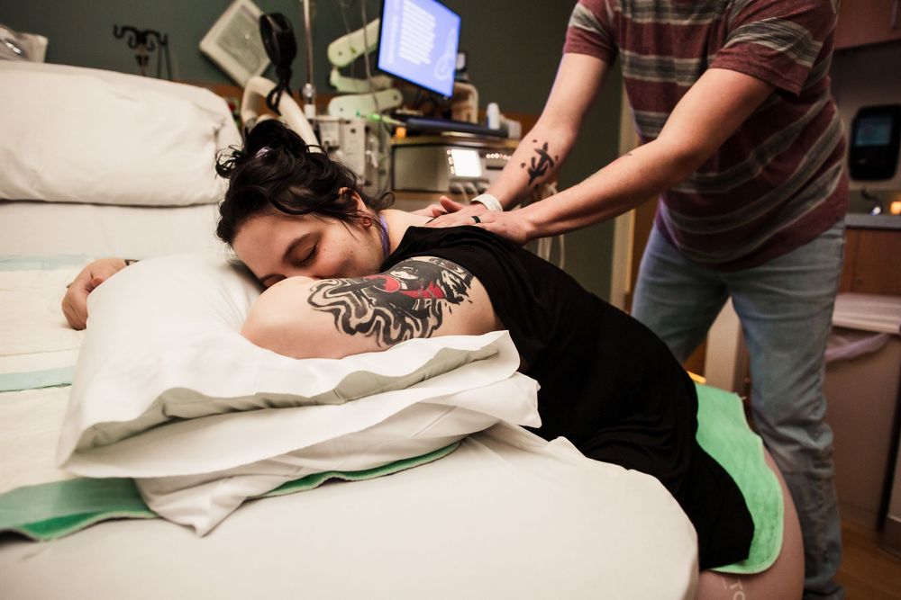 Side view of patient receiving medical care while lying on examination table.