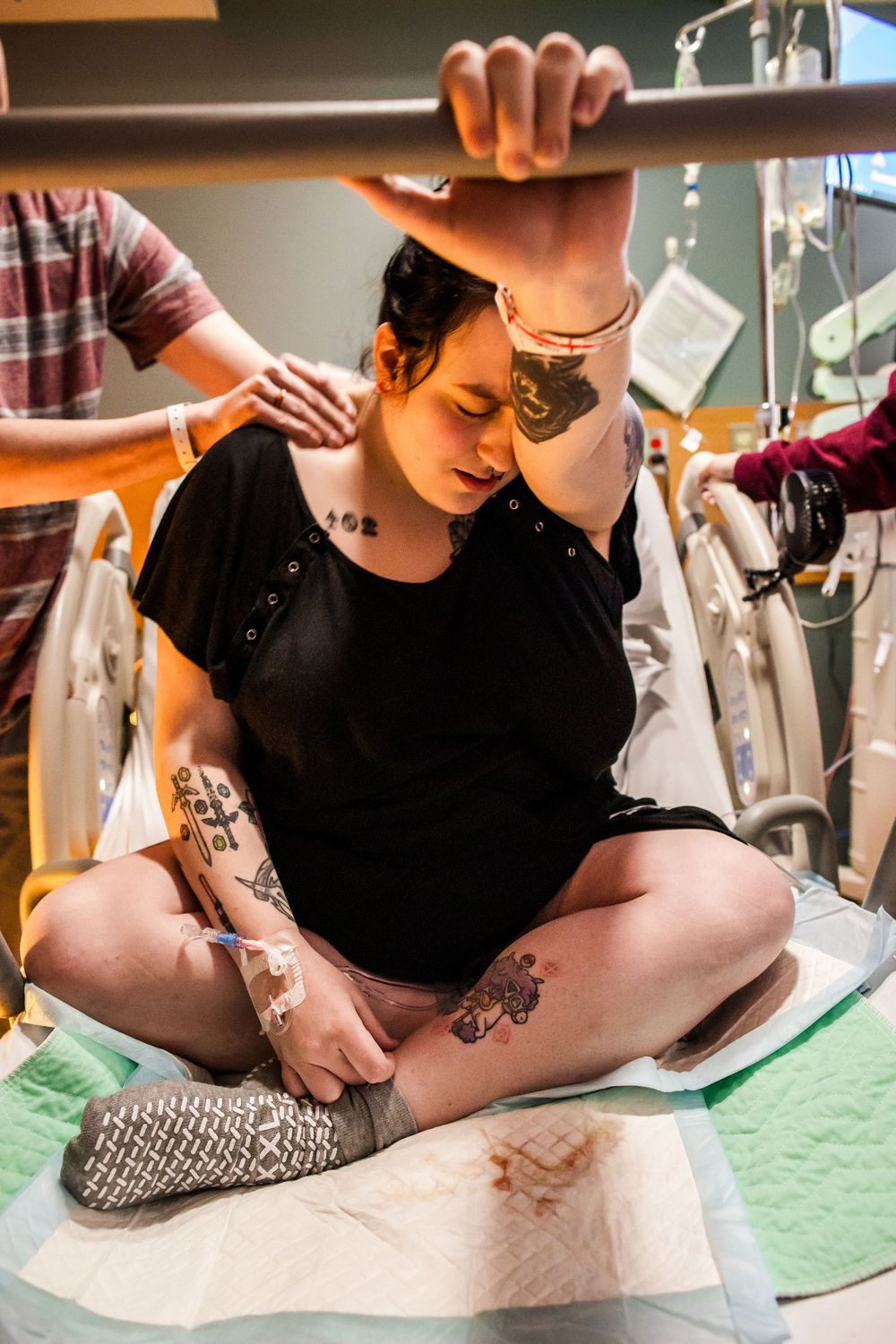 Patient wearing black shirt receiving medical care on examination table.
