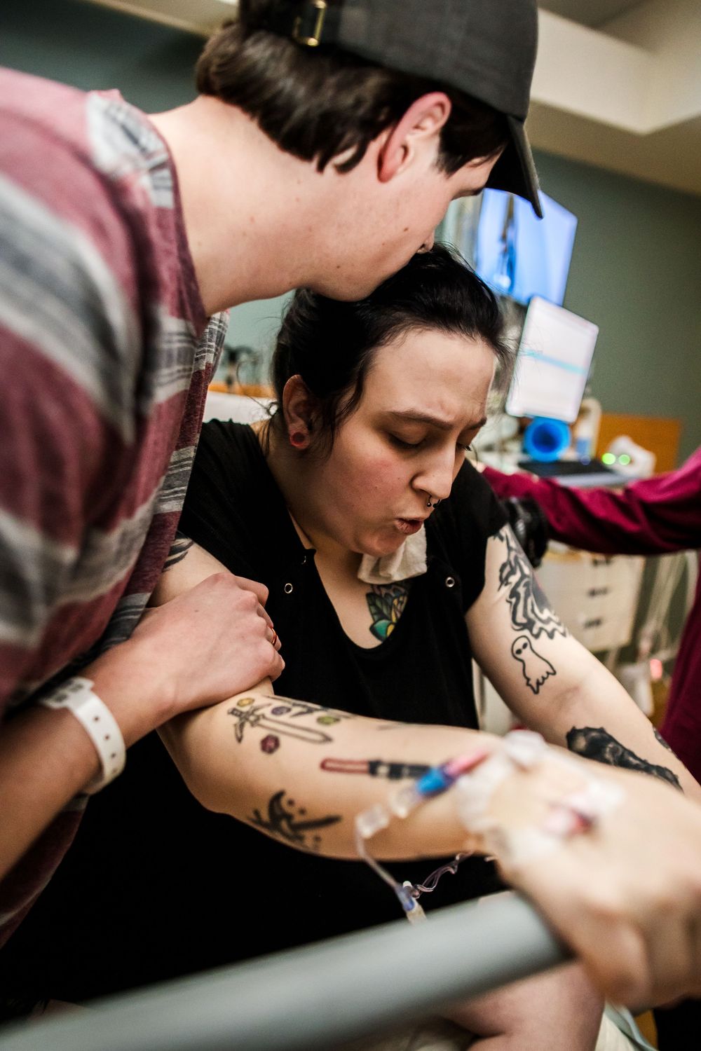 Medical procedure being performed in hospital room with monitoring equipment.