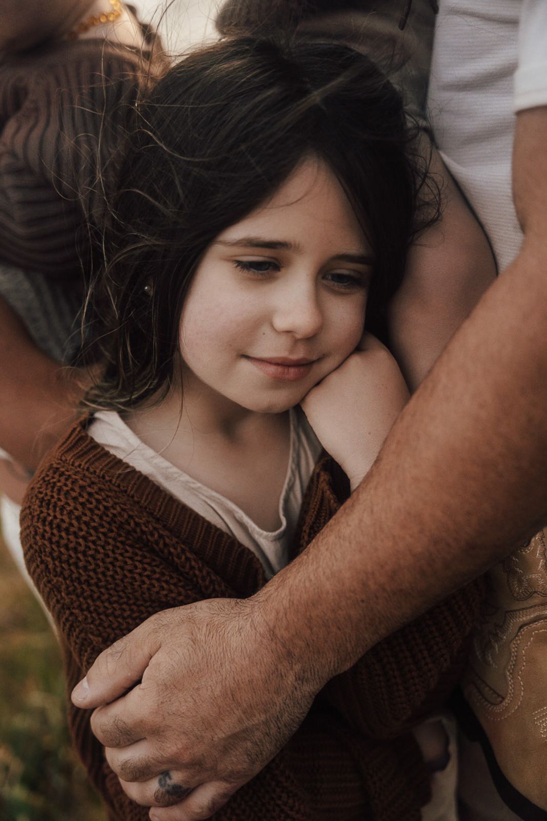 Portrait of a girl wearing a brown knit sweater being embraced in a tender moment outdoors during golden hour in Palatine