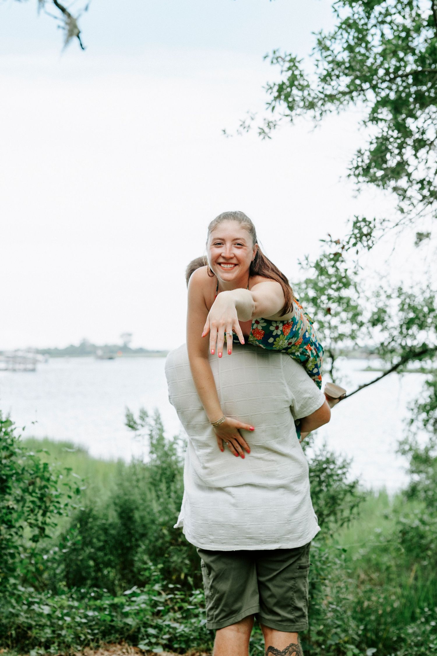 A playful couple shares a lighthearted moment in a natural outdoor setting.