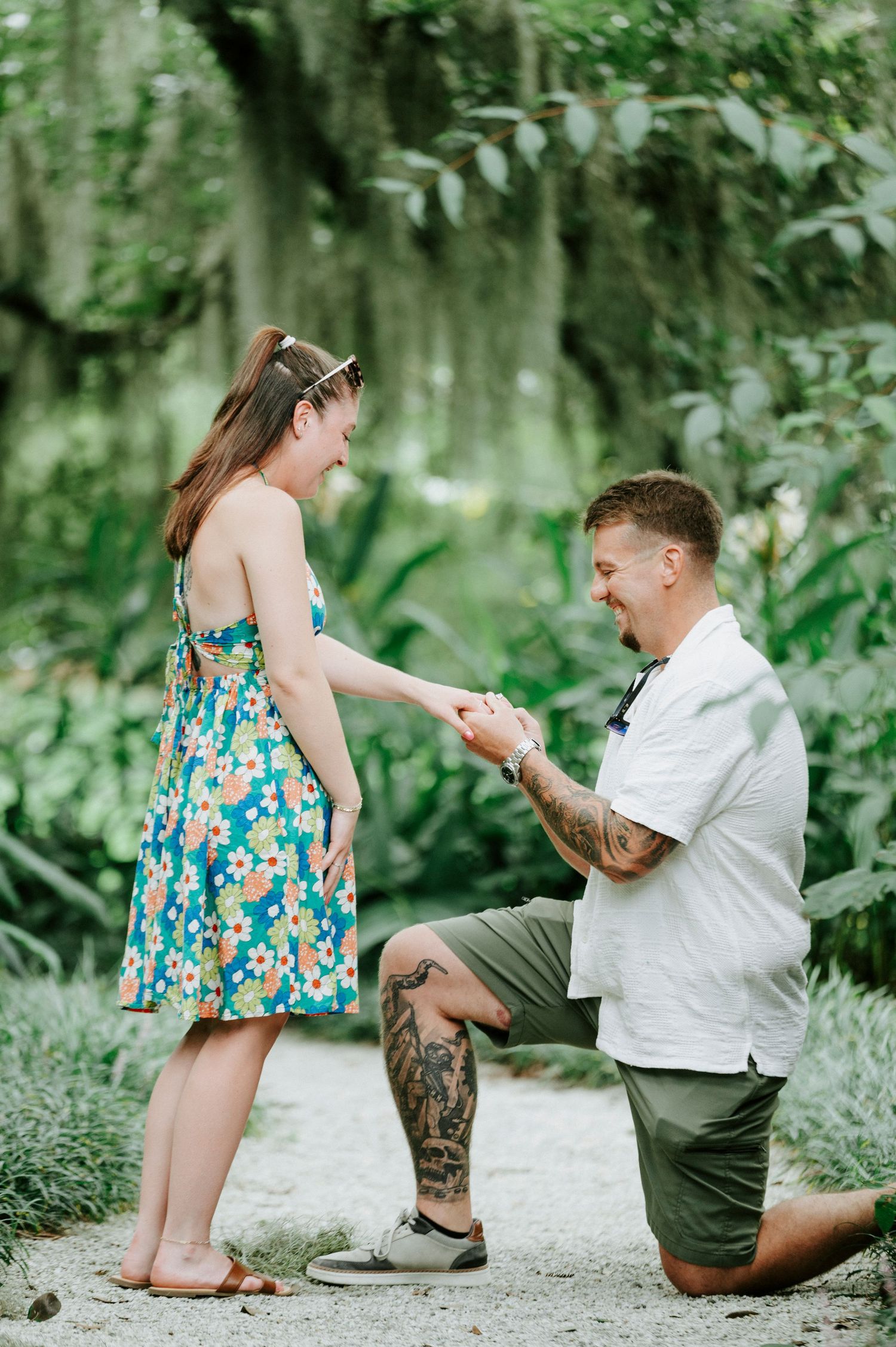 A romantic proposal scene with Spanish moss and tropical plants in the background.