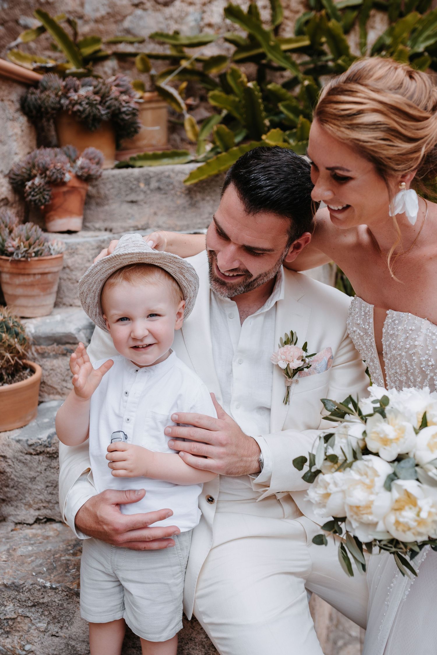 Eine Reihe von ehrlichen Hochzeitsfotos, die zärtliche Momente zwischen Familienmitgliedern vor einer rustikalen Steinmauer zeigen.