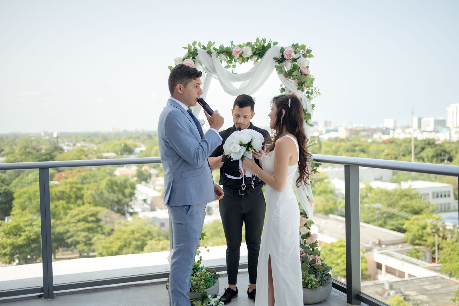 Outdoor rooftop wedding ceremony with scenic views of green landscape during daytime.