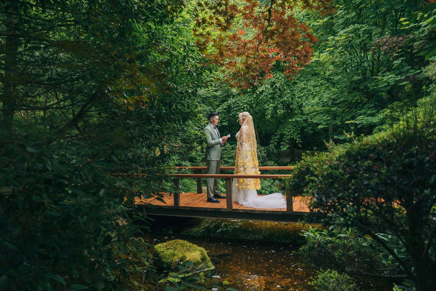 Lush green garden pathway with natural wooden structures and foliage.