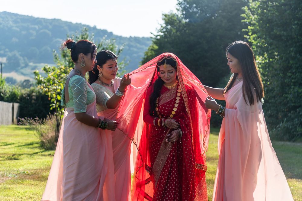 Outdoor wedding celebration with guests in pink attire against a mountainous backdrop.