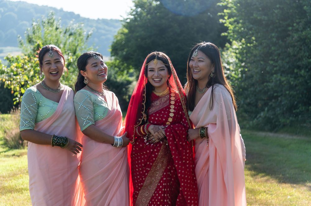 Wedding party in colorful attire posing together outdoors in natural lighting.