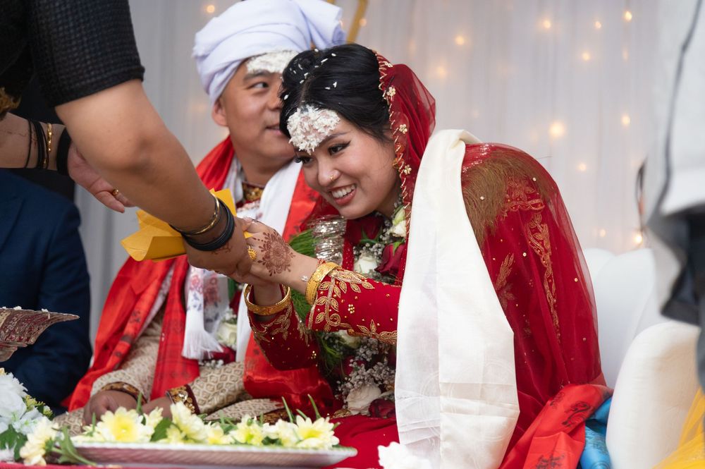 Guests celebrating at a traditional South Asian wedding reception with decorative lights.